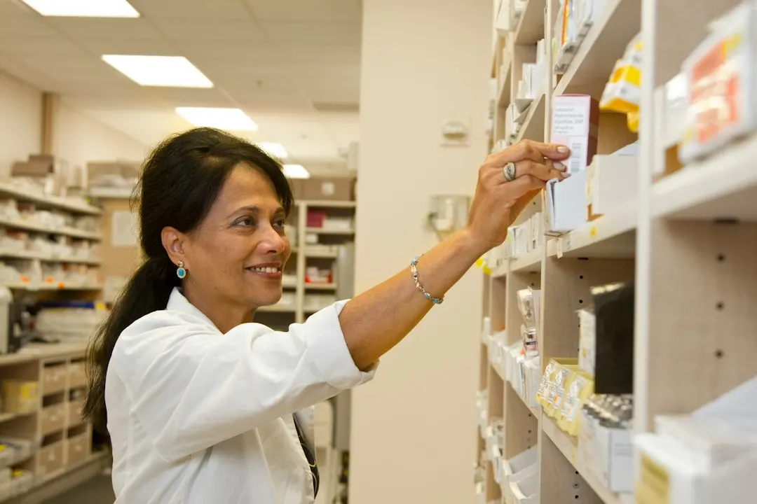 Pharmacist taking a medicine box from a shelf